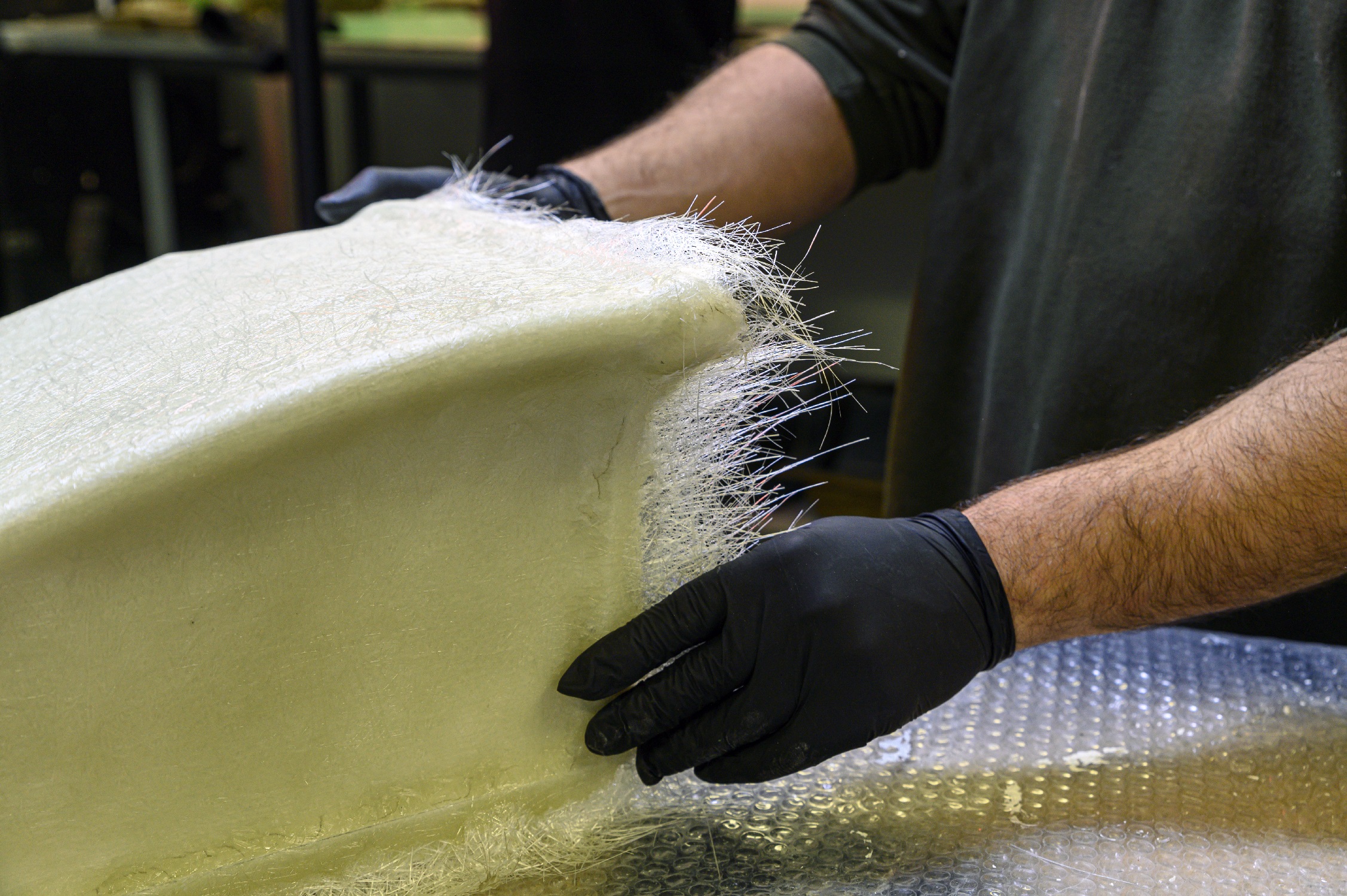 Fiberglass,processing:,worker,manually,realizes,a,component,in,glass,fiber.